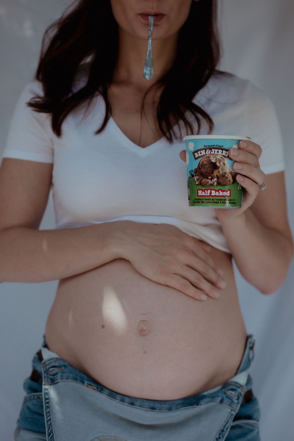 Pregnant woman holding Ben & Jerry's ice cream shows her belly in casual attire.
Portland Photographer
Maternity Photographer