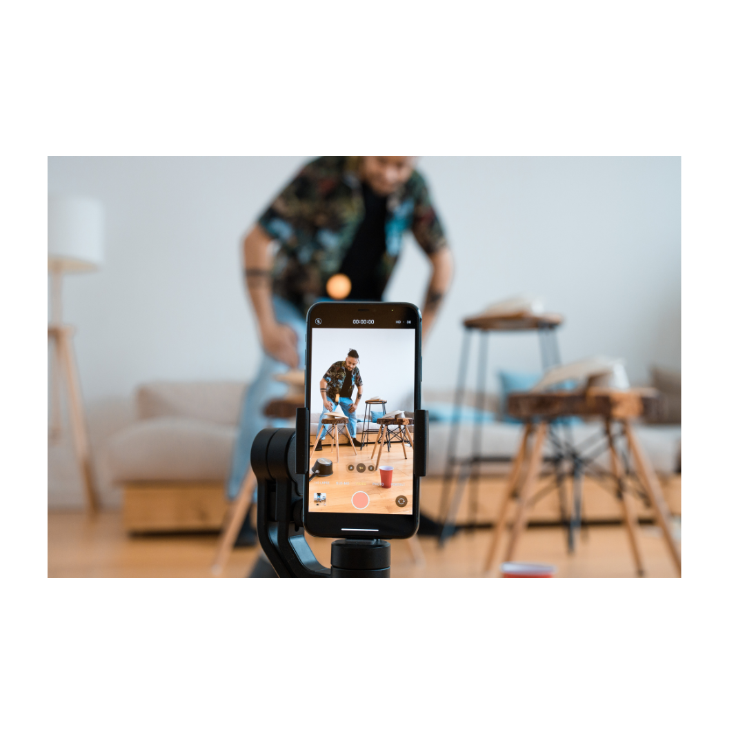 Smartphone screen displaying someone sitting in a living room setting.