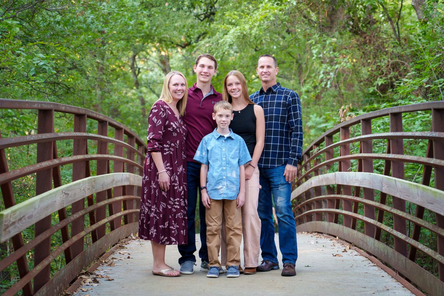 Fall family mini session Keller Texas standing on wooden bridge fall warm colors teenage kids Christmas cards photos