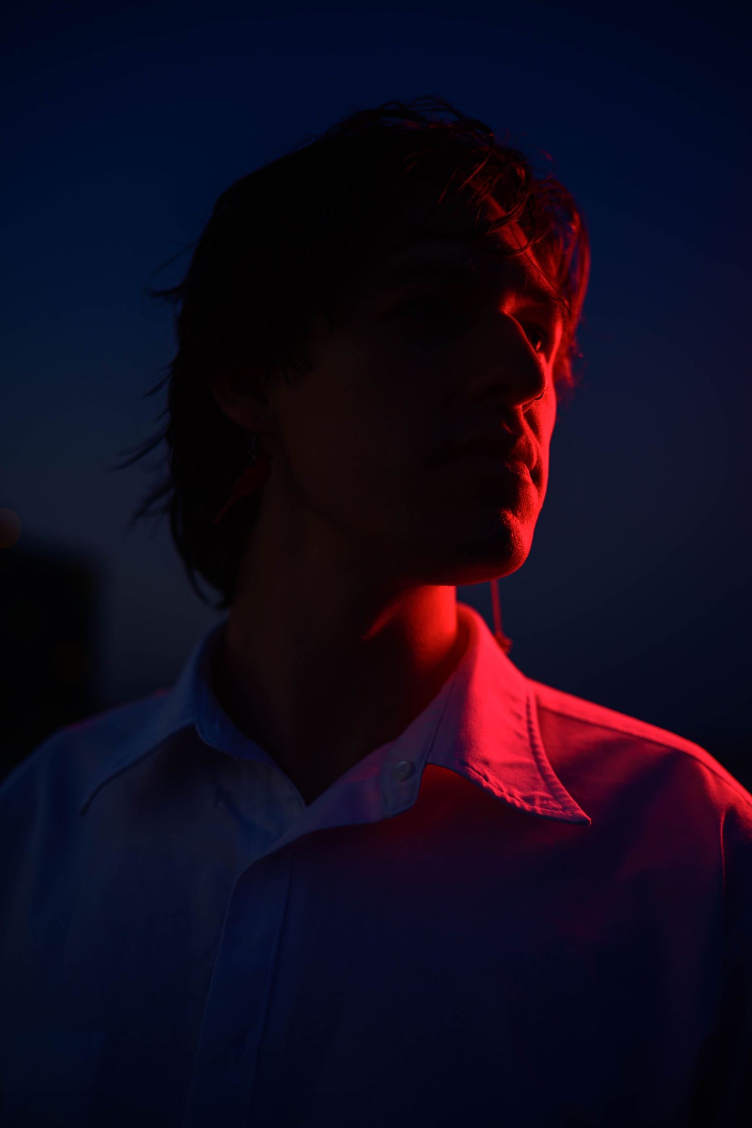 Dramatic red lighting creates a silhouette against a dark blue twilight sky.