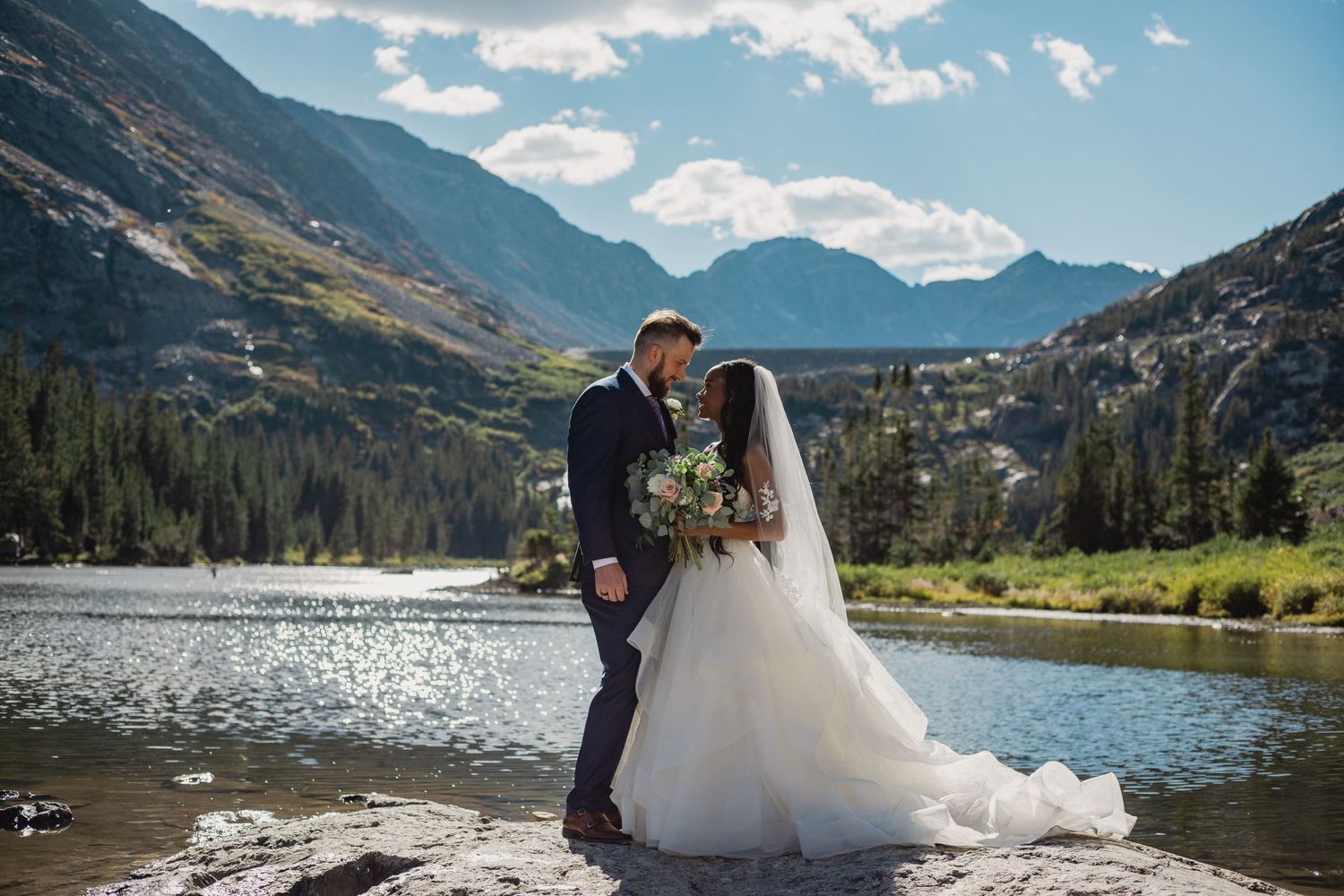 Bride holding her bouquet, standing by the crystal-clear Blue Lakes, highlighting a scenic spot from the Breckenridge