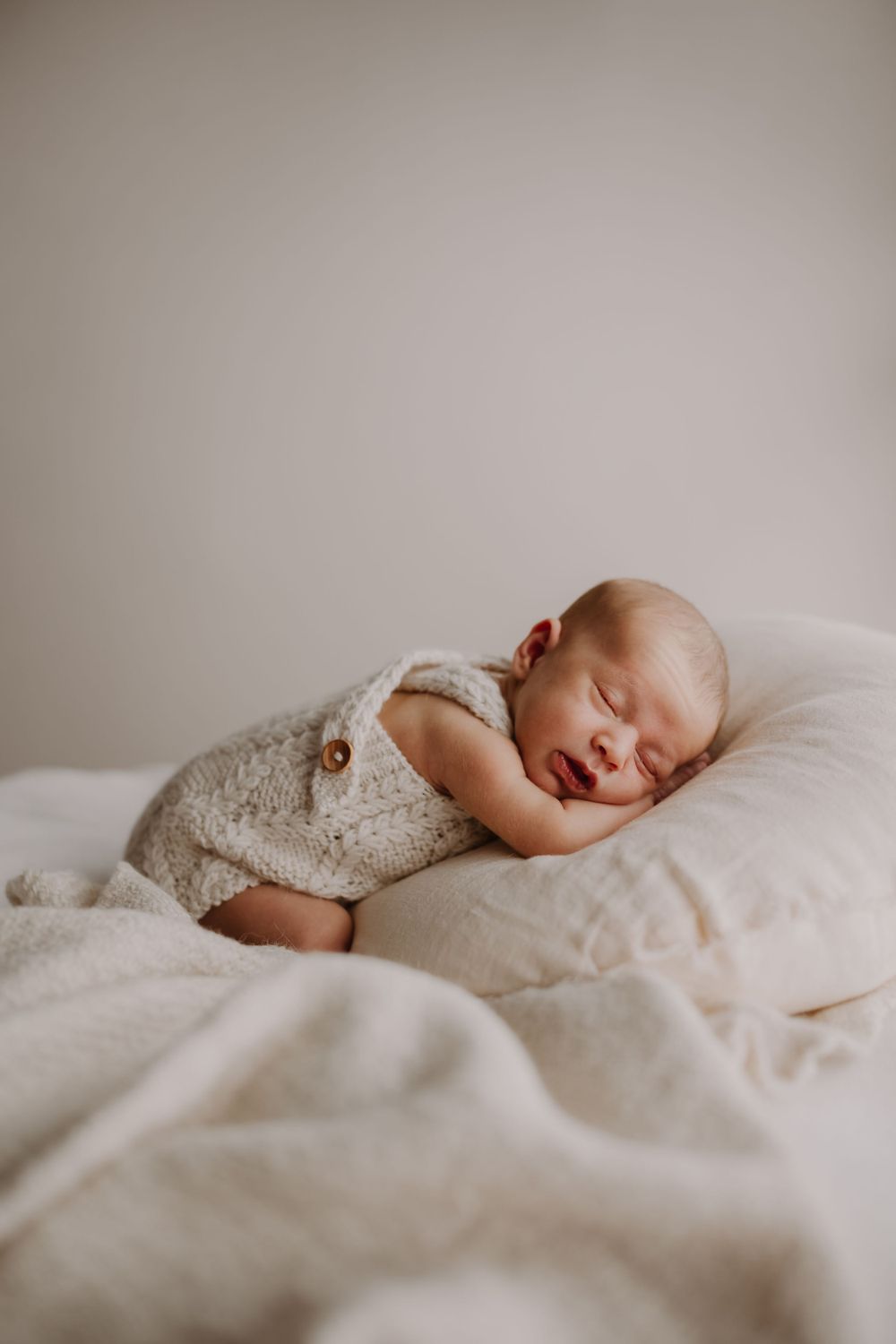 Newborn baby naturally posed, sleeping peacefully during an in-home newborn photo session. Westport NZ
