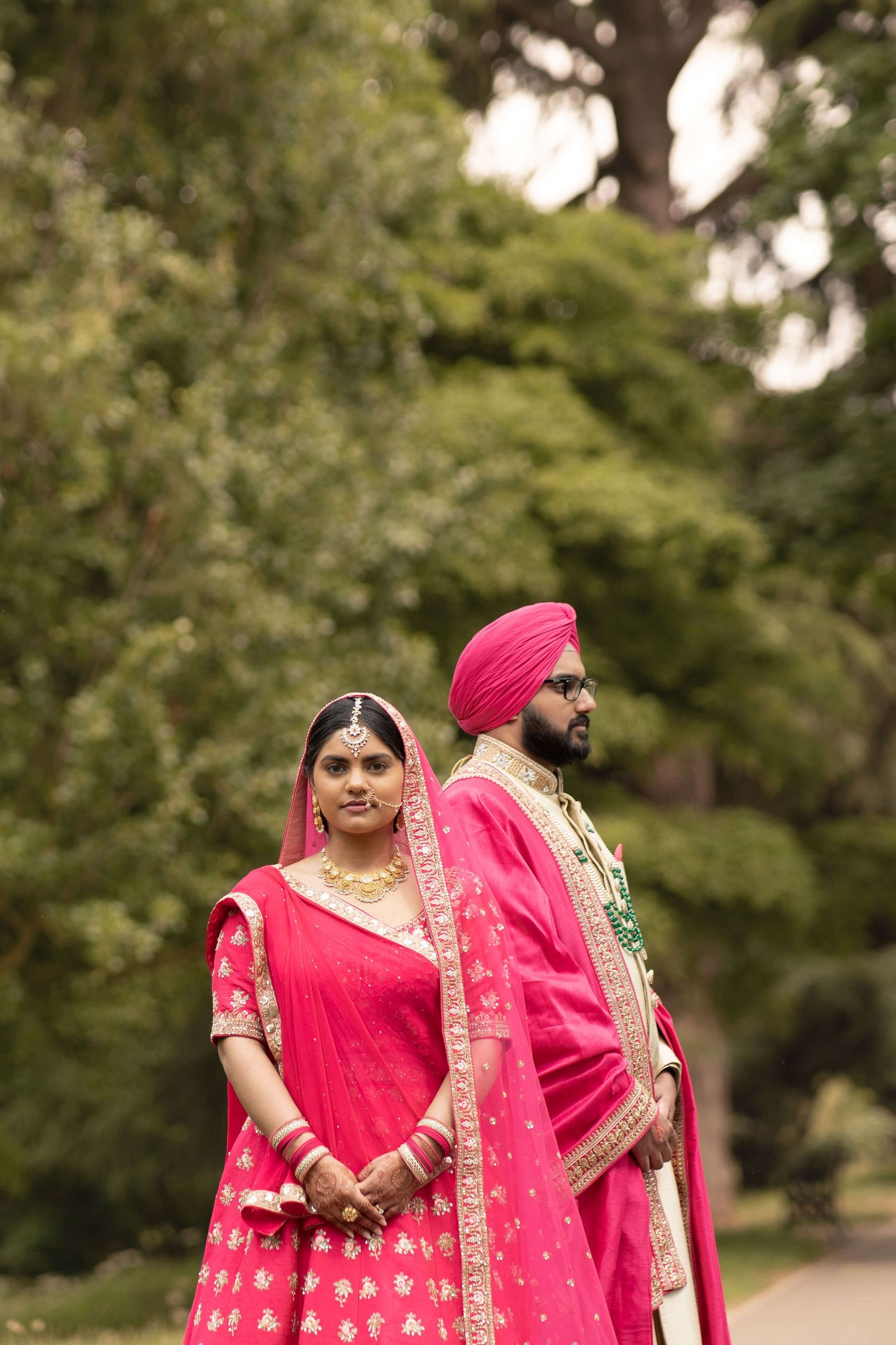 Newly weds posing attending the gurdwara for their anand karaj, wearing pink kurta
