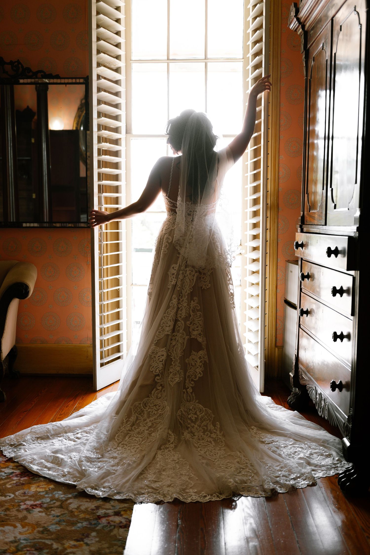 Bride wearing pearl jewelry and lace veil with soft makeup and white strapless wedding gown.