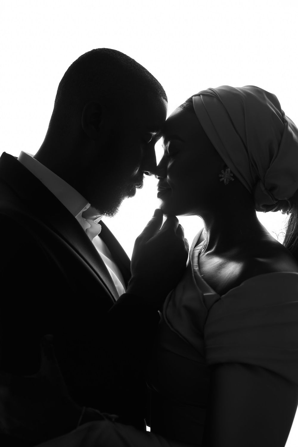 Dramatic black and white silhouette portrait of romantic couple in intimate pose.