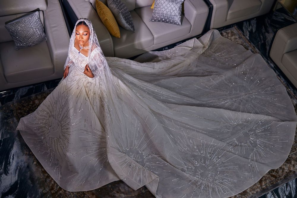 Overhead view of bride in elaborate white wedding gown with intricate lace details.