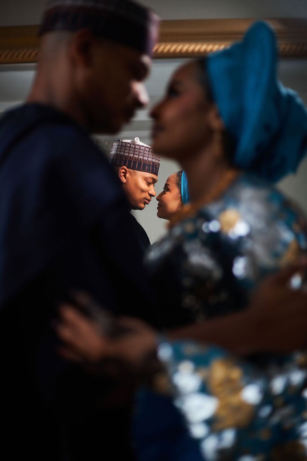 Intimate close-up portrait of couples embracing in traditional African attire.