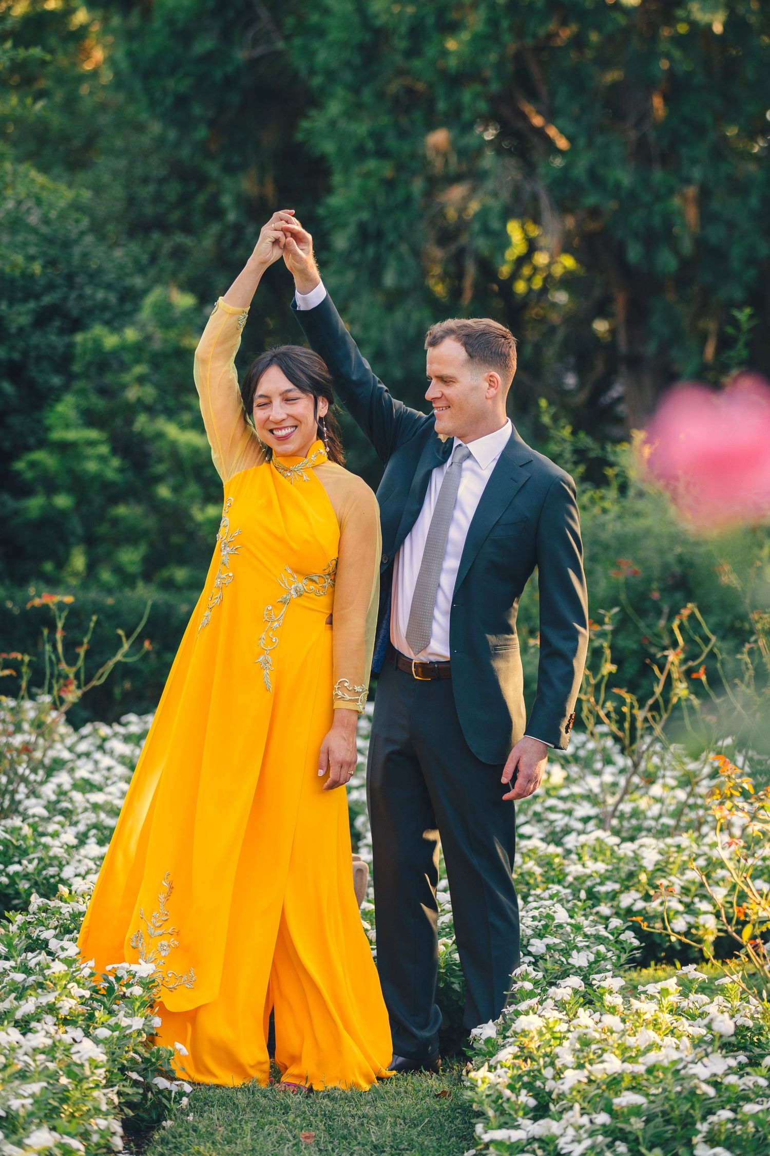 Couple sharing romantic moment among tall classical columns against blue sky at the arboretum