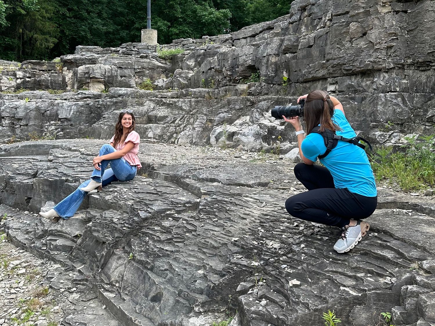 Professional photographer Christina Newby capturing a portrait session outdoors on rocky terrain