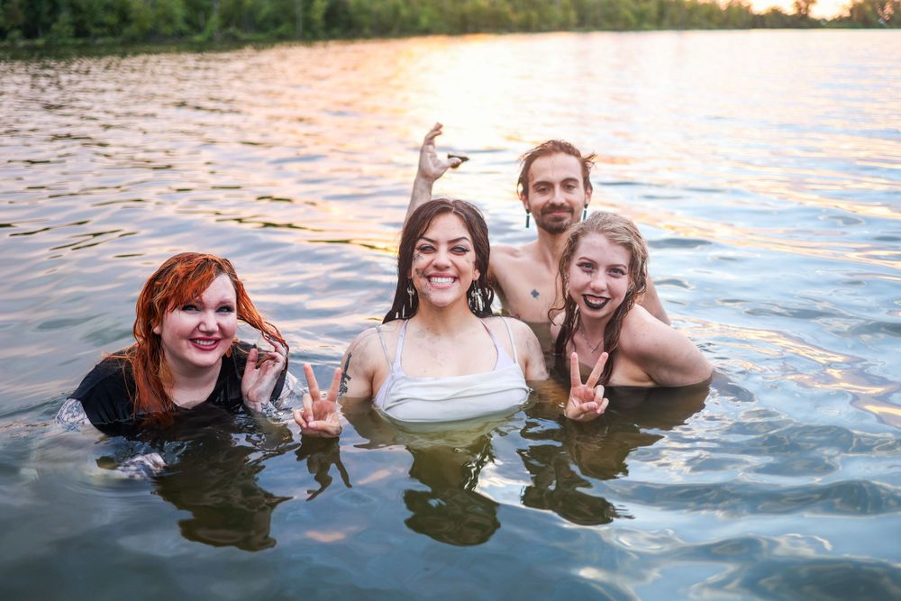 Group of friends enjoying a fun sunset swim in a lake.