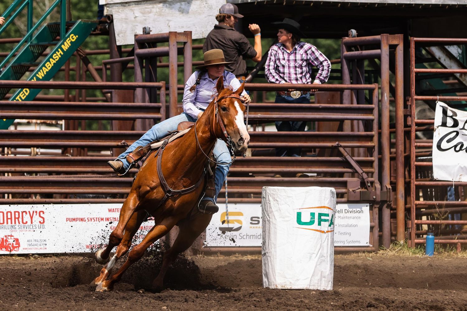 Rodeo competitor races around a barrel on horseback during a competition event.