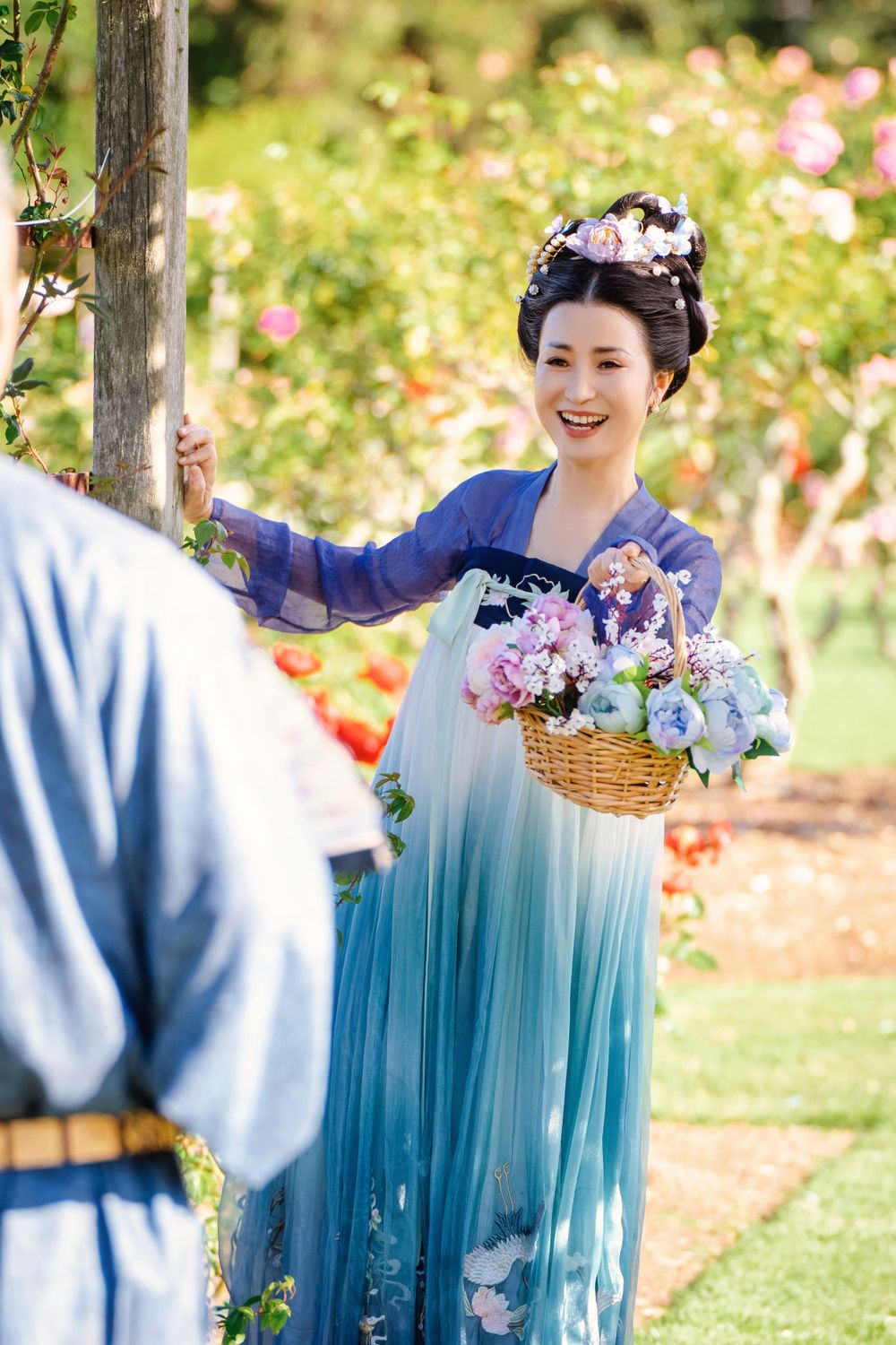 Dynamic natural sunlight portrait of a couple hugging and dancing in Tang Dynasty Hanfu among blooming roses, by Imagine Image Studio.