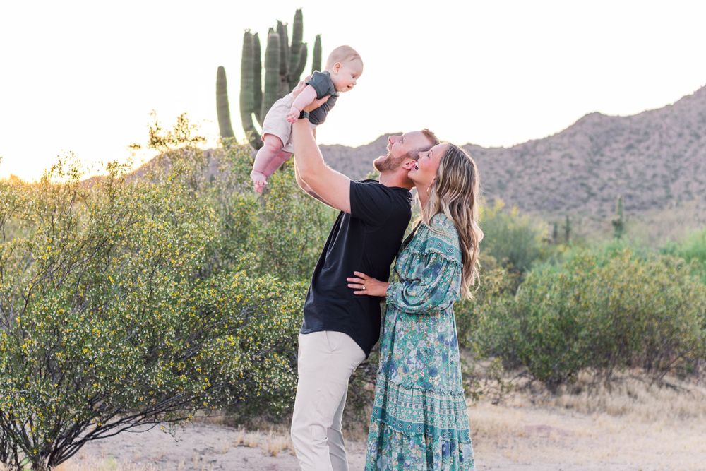 Family photoshoot in Arizona desert with saguaro cacti at golden hour.