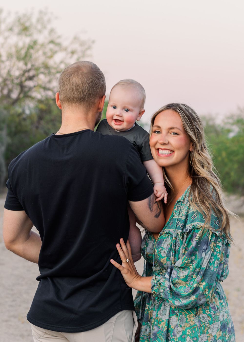 Happy family playing and laughing together in desert landscape at sunset.