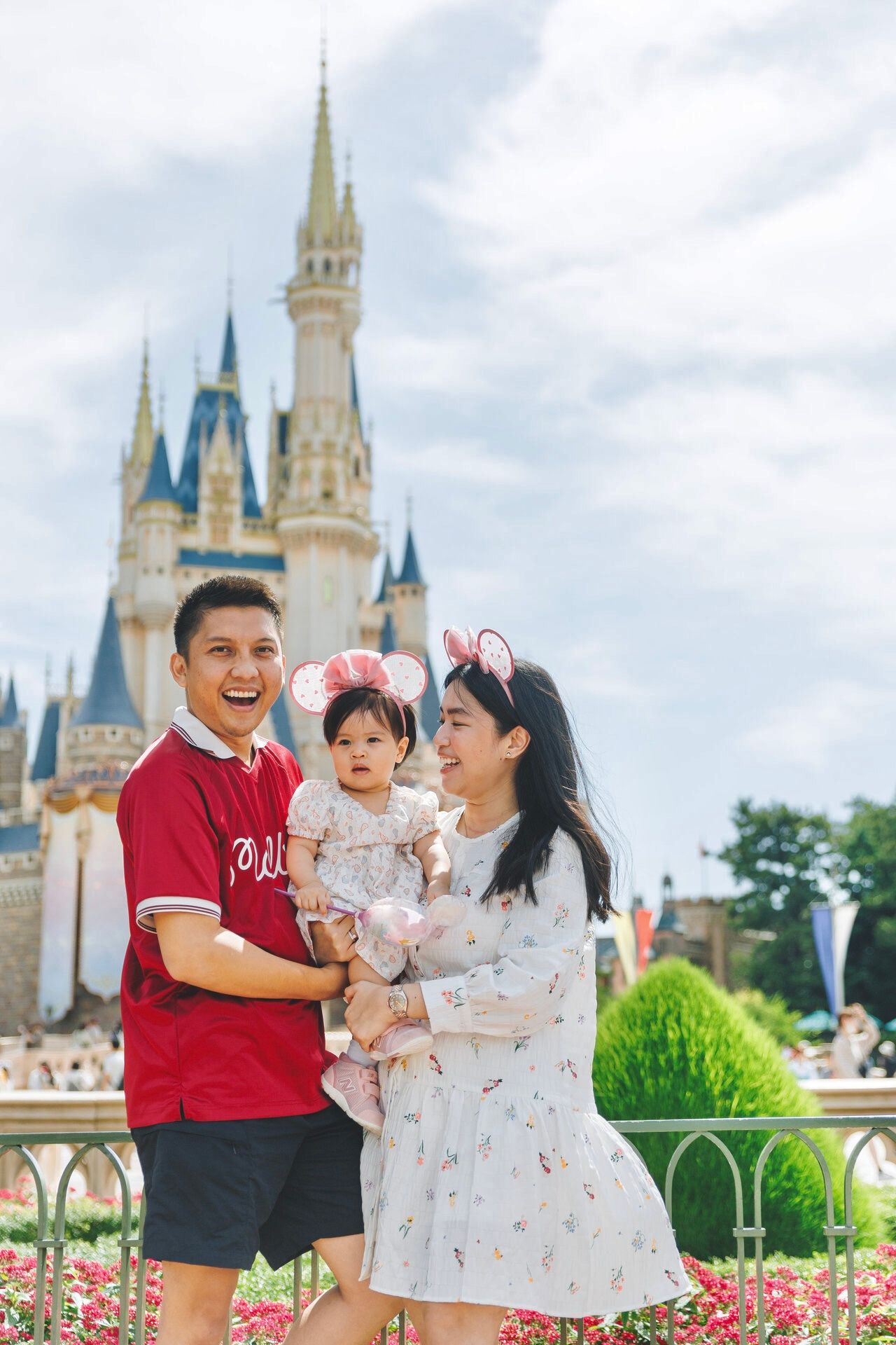 A happy family poses together in front of Cinderella Castle at Disney World.