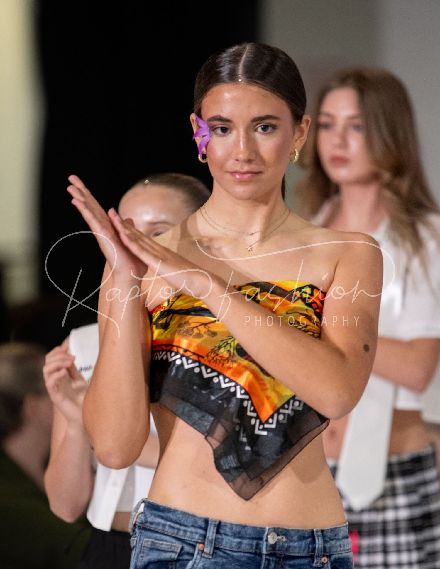 Model in creative upcycled top made from food packaging on fashion runway.