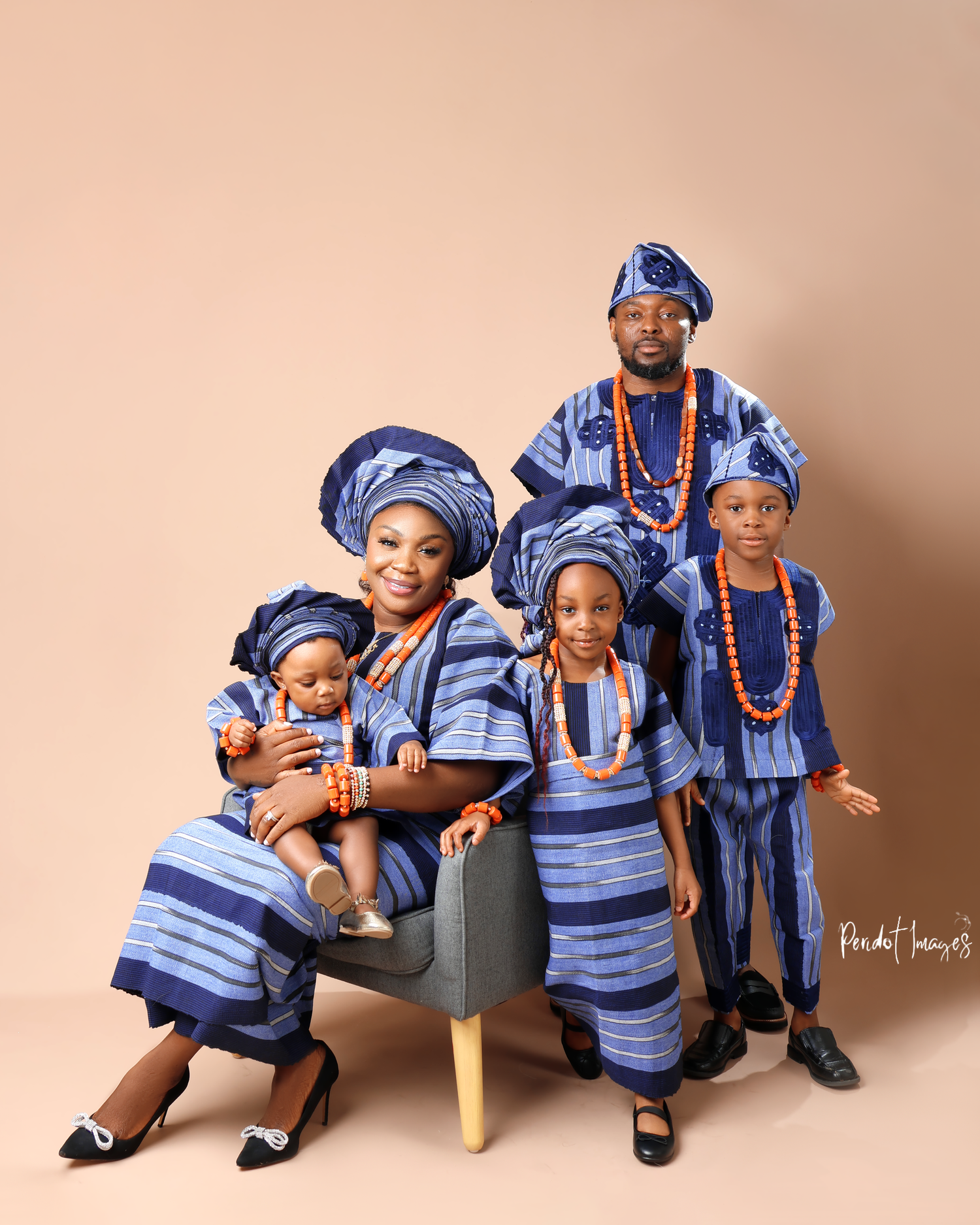 Family wearing traditional blue African attire poses together for portrait.