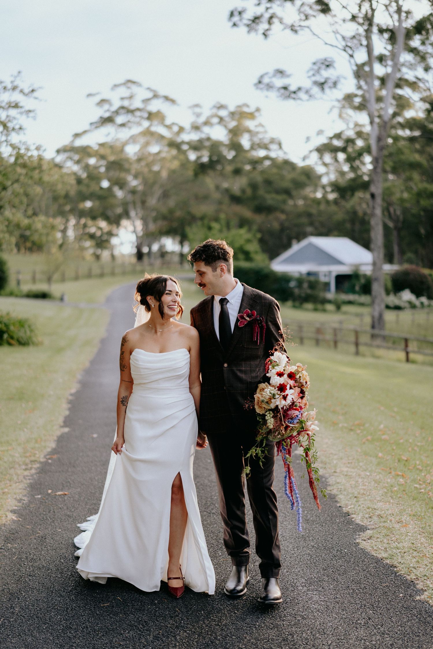 Romantic wedding couple in formal attire sharing intimate moments against a dark outdoor backdrop.