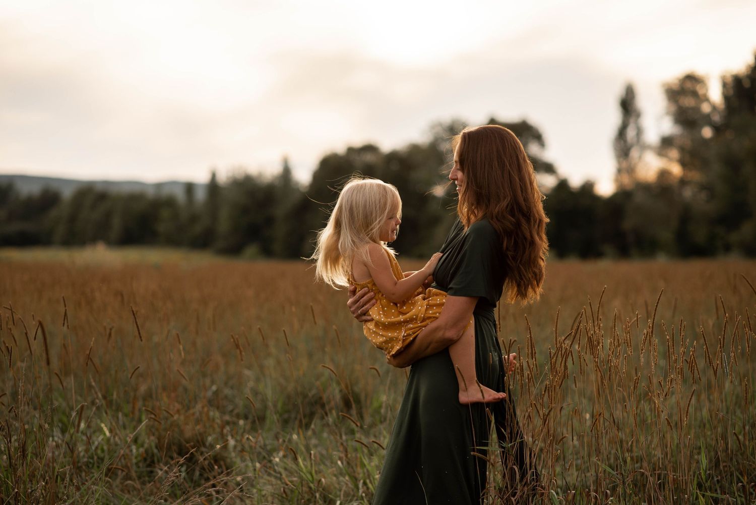 A tender moment between two figures in a golden wheat field at sunset.