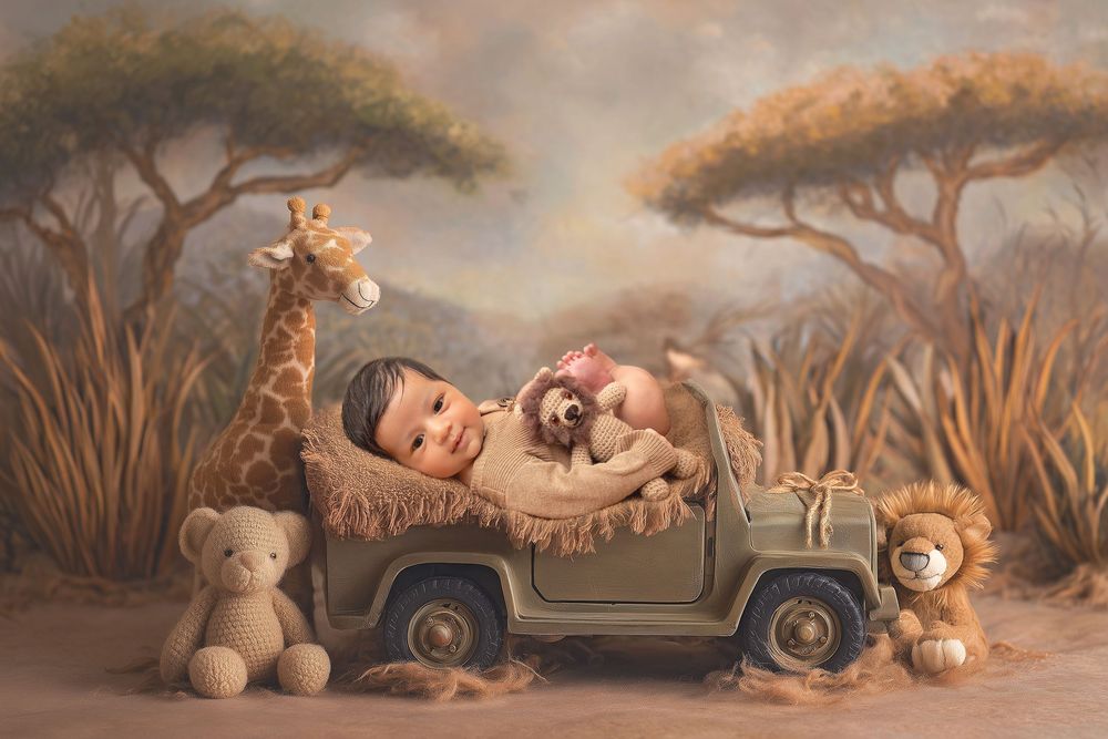 Sleeping newborn in safari jeep surrounded by giraffe and lion stuffed animals.