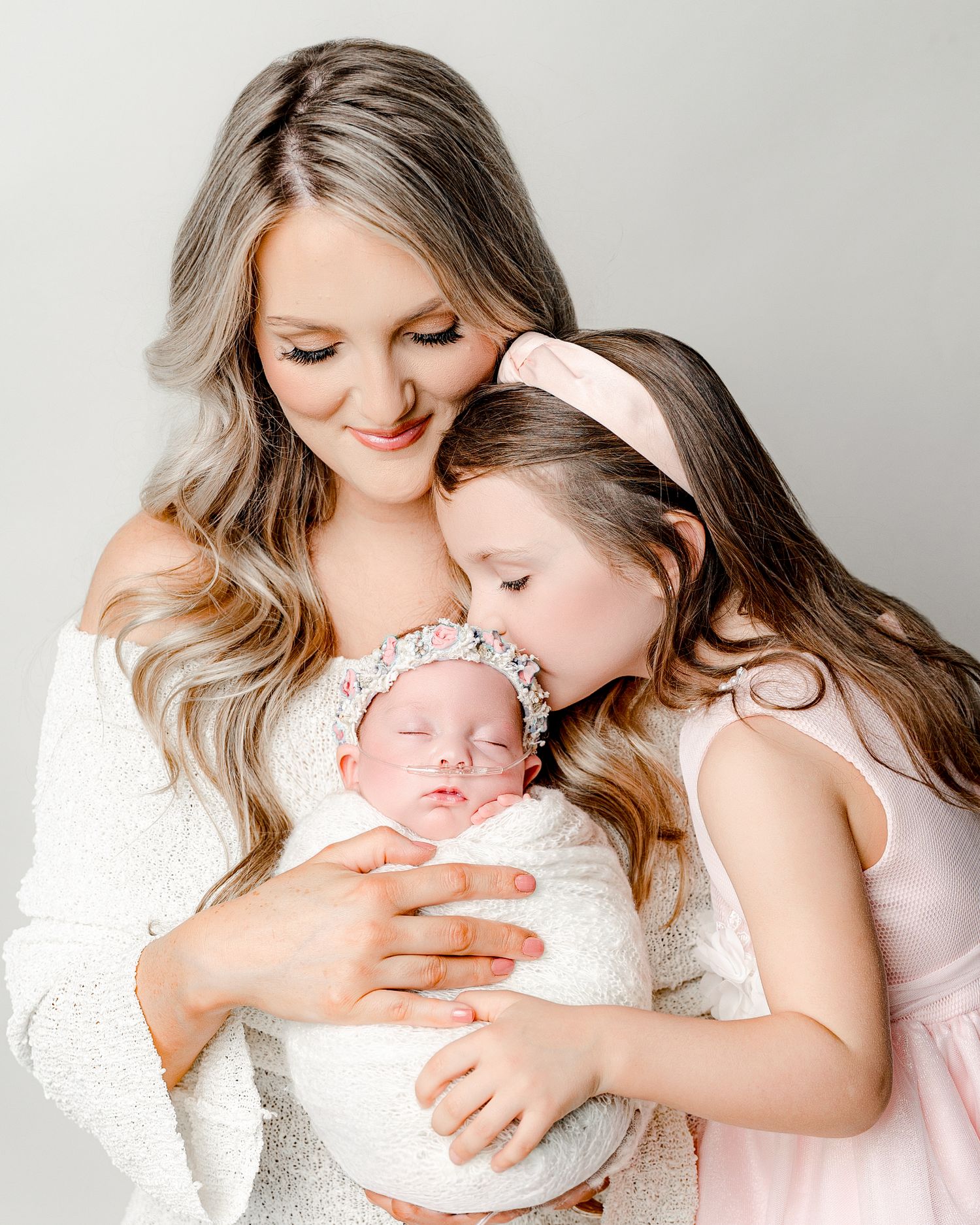 A tender collage of intimate newborn and parent moments captured in soft, warm lighting against neutral backgrounds.