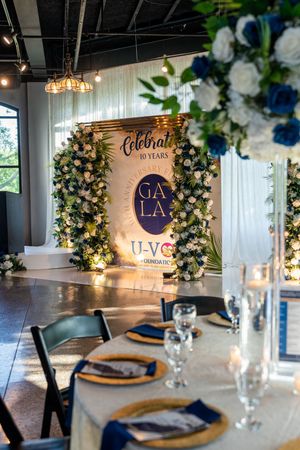 Elegant gala venue decorated with floral arrangements celebrating U-VOL Foundation 10 years.