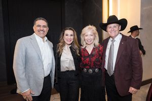 Four elegantly dressed guests pose together at a Western-themed gala event, with cowboy hats visible in the background.