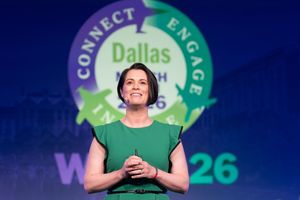 Woman in green dress speaking on stage at Dallas Connect Engage 2026 conference event.