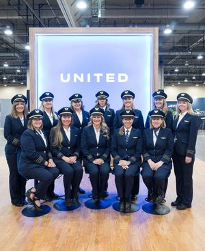 Group of United Airlines female pilots posing in uniform at a United Airlines recruitment event.