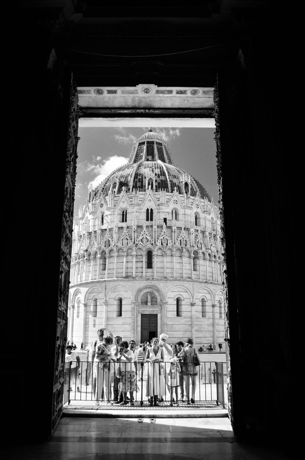 Schwarz-weiß Aufnahme mit Blick aus dem Dom von Pisa auf das Baptisterium.