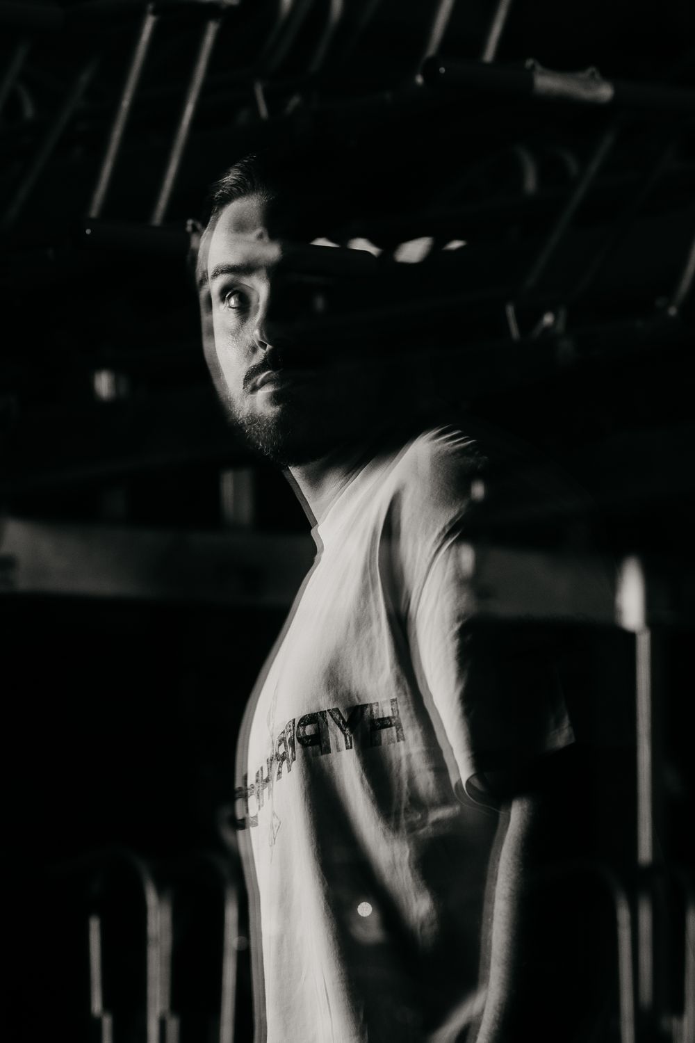 Dramatic black and white photo sequence showing someone moving in dark lighting against a stark background.