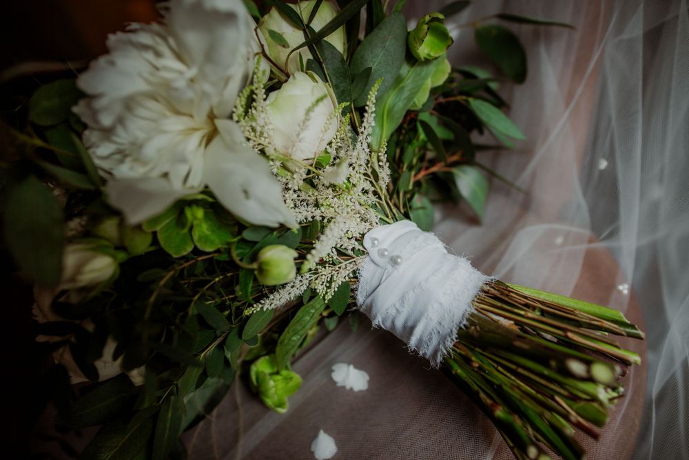 Elegant white and green wedding bouquet wrapped in ribbon.