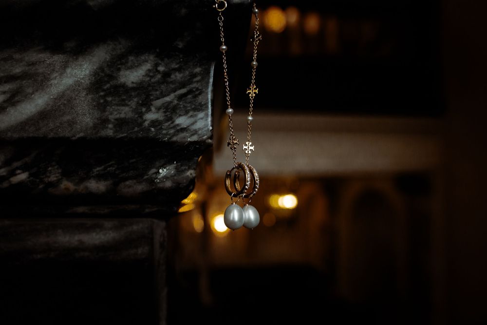A delicate hanging jewelry detail shot illuminated by warm background lighting.