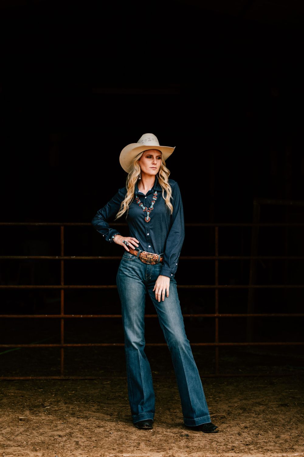 Katie Perschbacher, a PBR stock contractor poses in a barn in Tupelo, Oklahoma with her genuine turquoise jewelry.