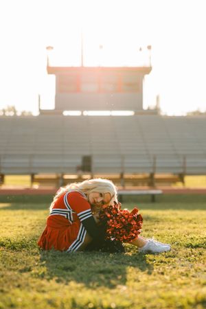 A Caney Valley High school senior cheerleader poses for her senior photos in her cheer uniform at the Ramona, Oklahoma football field.