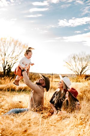 A bold, true-to-color photo of two young sisters and their parents posing at sunset in Kiefer, Oklahoma at Ogie Farms.