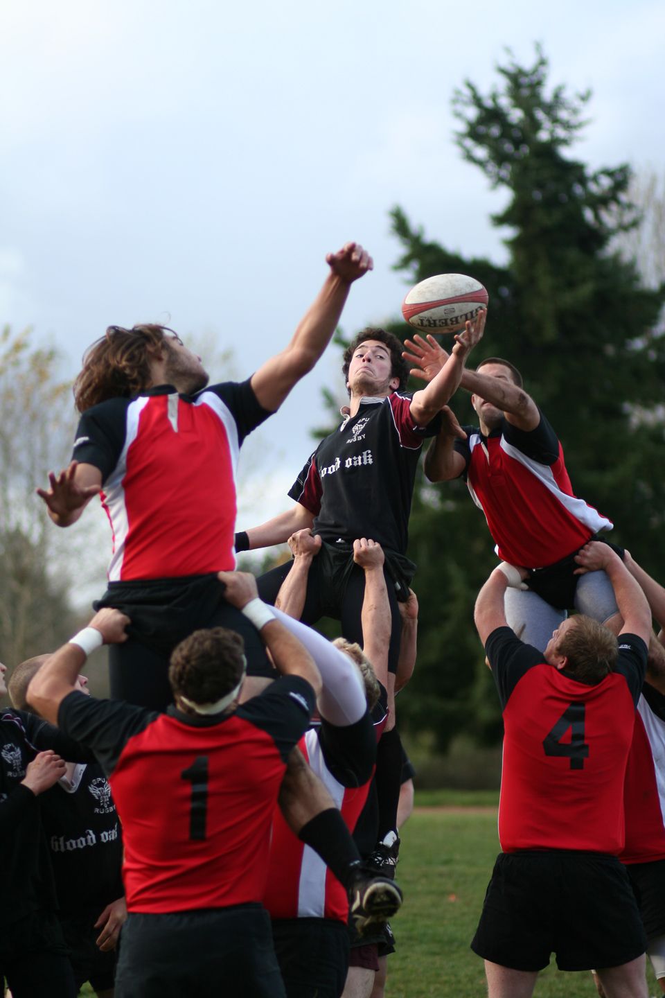 Rugby players competing for ball during lineout play in match.