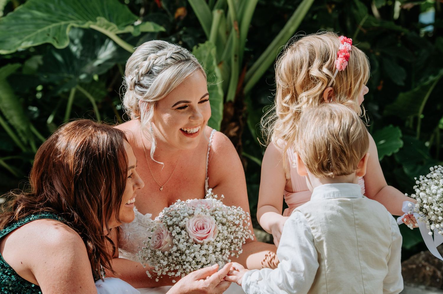 A candid wedding moment shared between people holding baby's breath bouquets in a garden setting.