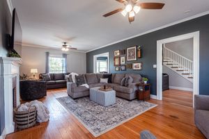 Modern living room interior with gray walls, hardwood floors and contemporary furniture layout.