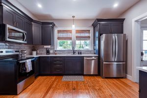 Luxury kitchen featuring dark wood cabinets, stainless appliances and butcher block countertops.