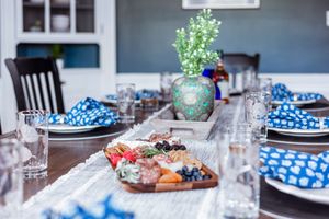 Dining table set with blue and white polka dot napkins and fresh flower centerpiece.