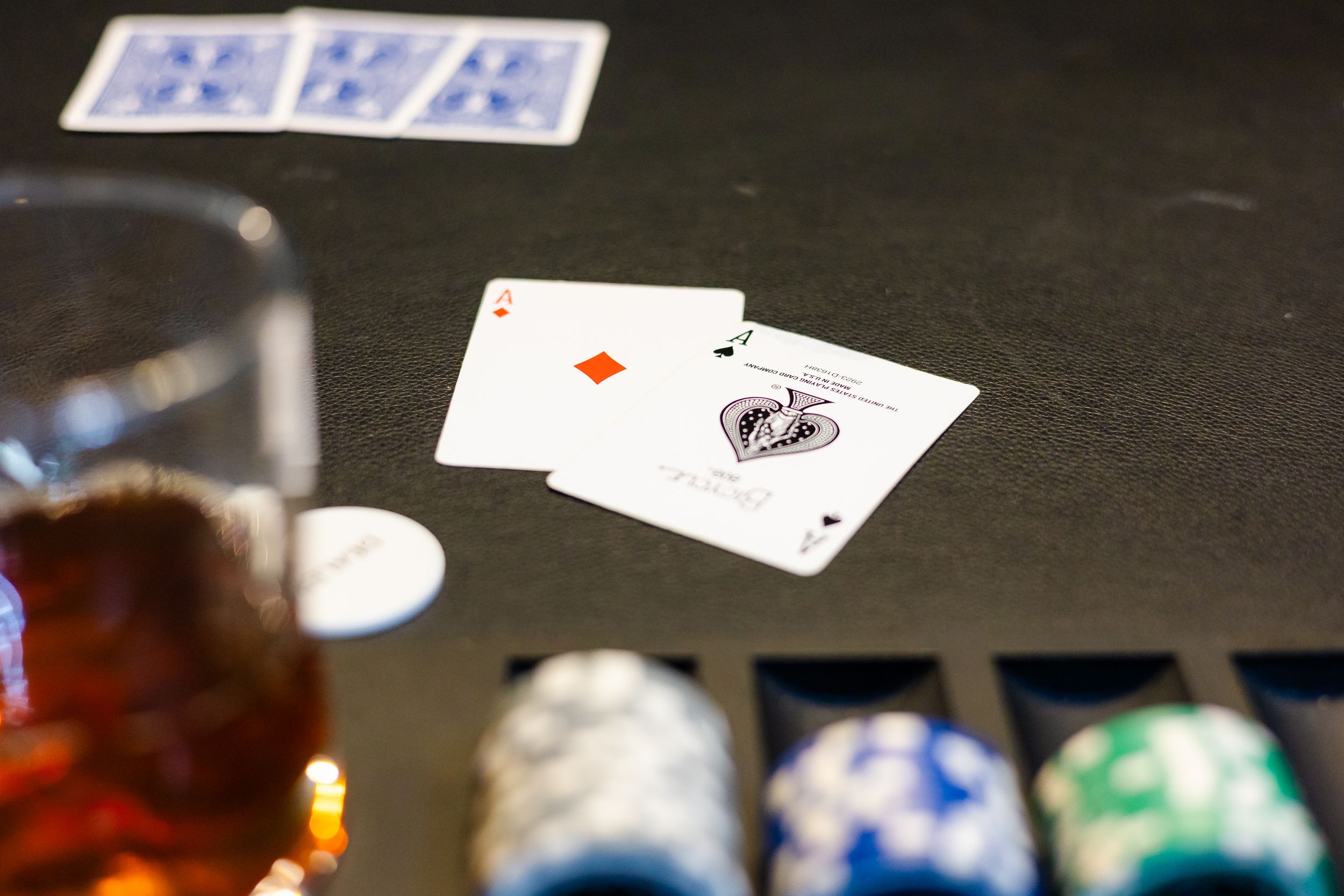 Playing cards and poker chips scattered on dark wooden gaming table during casino night.