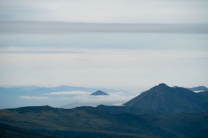 Distant mountain peaks and valleys viewed through hazy conditions with layered ridgelines.