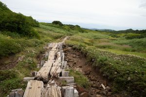 Wooden boardwalk trail winding through rocky mountain terrain.