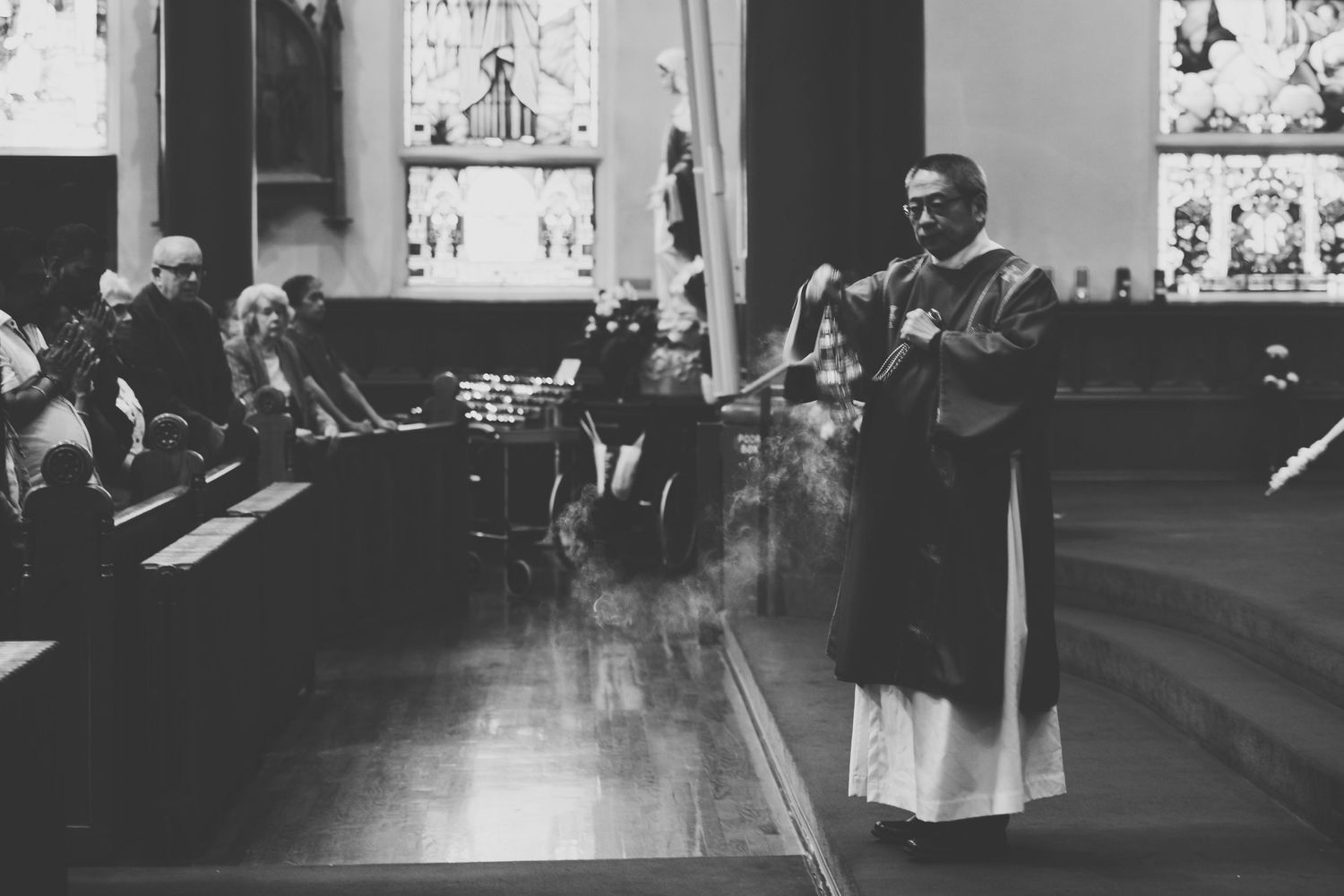 a deacon swings the mass incense onto the parishioners during mass at st andrew's cathedral in victoria, bc.