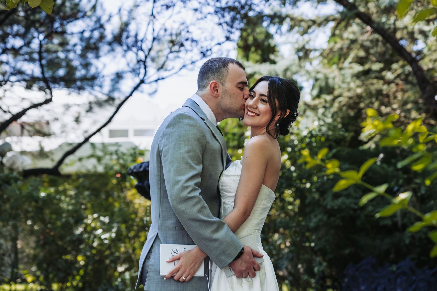 A couple raises champagne glasses in celebration during a wedding reception, with the bride wearing a delicate veil.