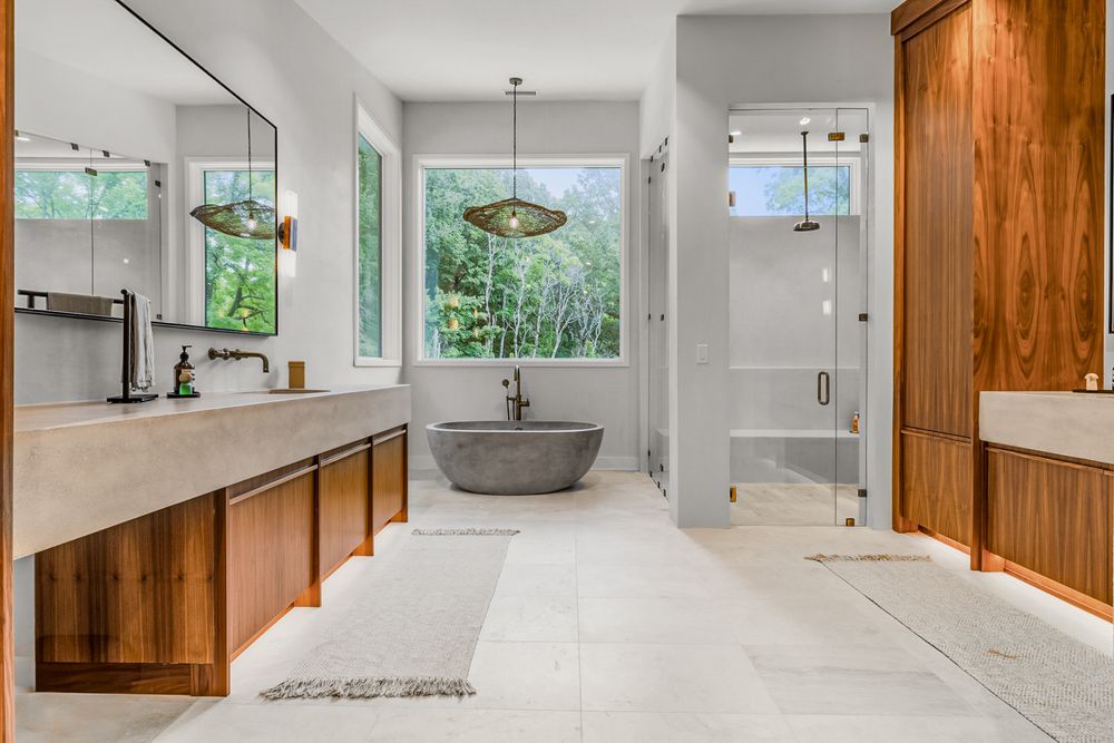 Modern bathroom interior with white walls, wooden accents, gray tile floors and dual floating vanity cabinets.