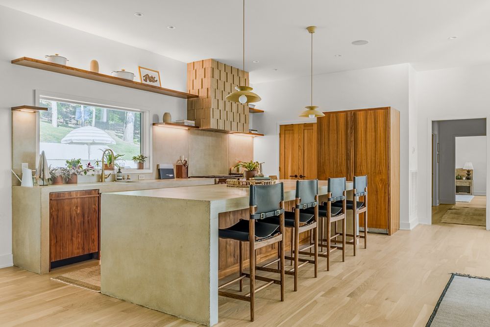 Modern basement renovation with floating wood shelves and bar seating along a sleek minimalist counter.