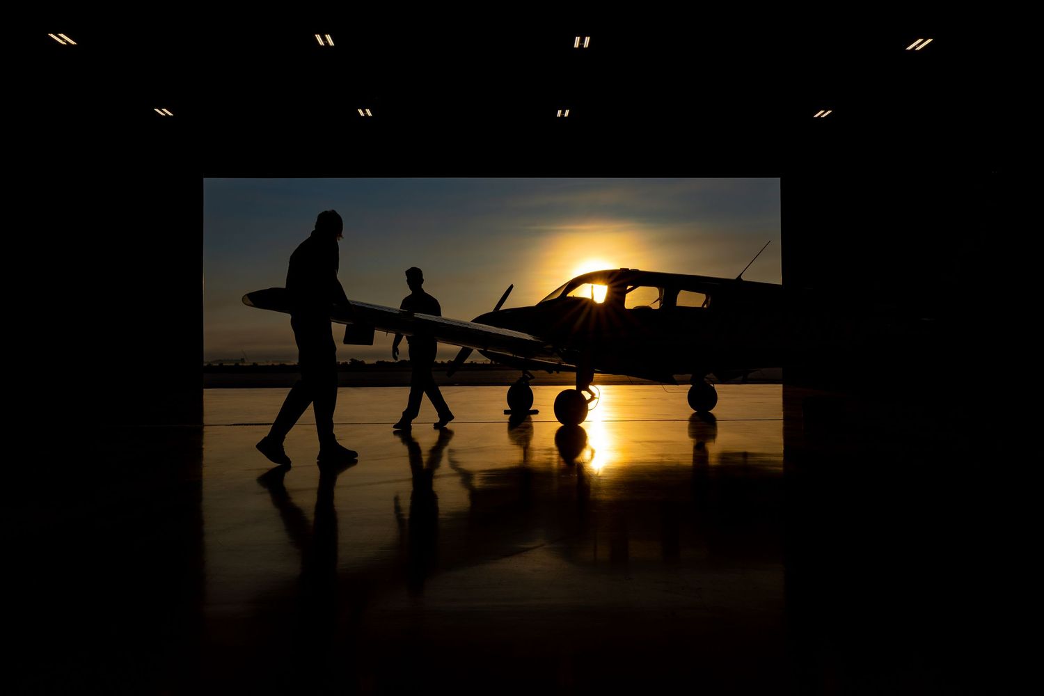 Silhouettes of people walking against a dramatic sunset backdrop.