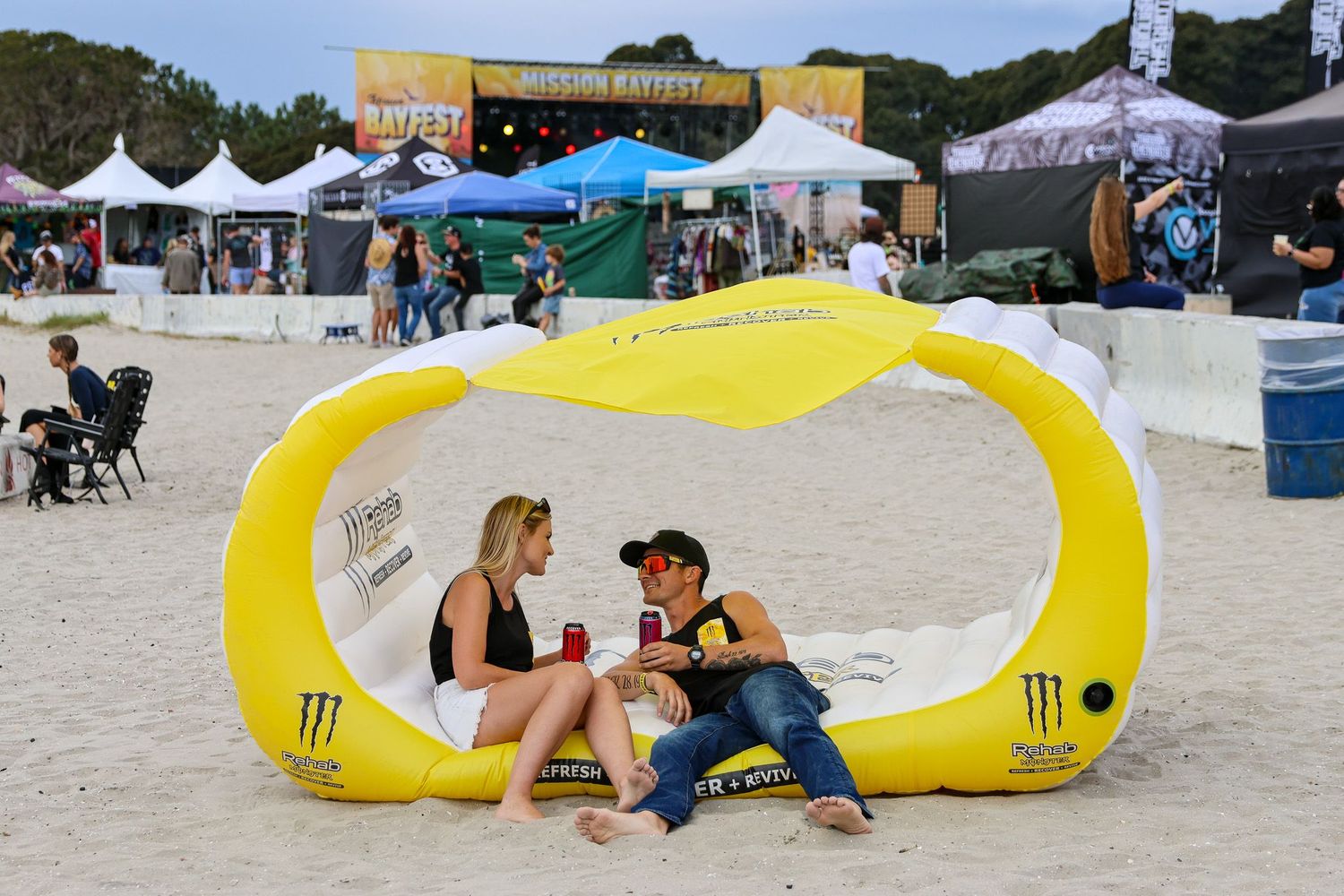 San Diego event photography of a couple relaxing in a Monster Energy inflatable lounge at Mission Bayfest music festival.